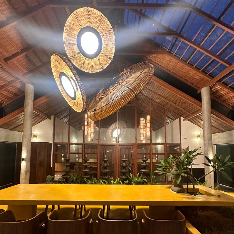 Large Lilypad bamboo chandelier with woven texture hanging over a modern dining table in a Japandi style interior.