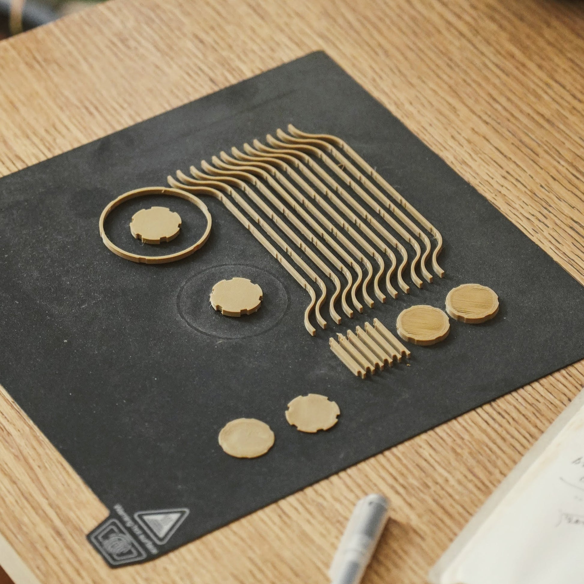 Decorative black mat with gold geometric designs on a wooden surface.