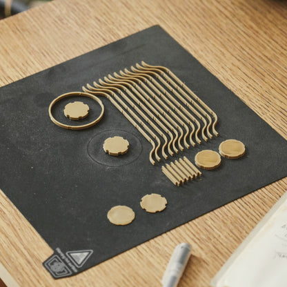 Decorative black mat with gold geometric designs on a wooden surface.